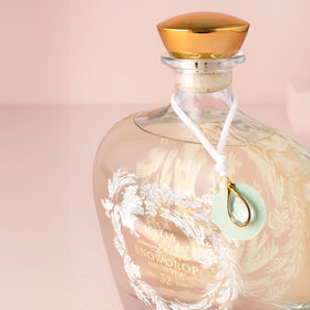 Lollia Snowdrop bottle closeup with etched frost and elegant details.