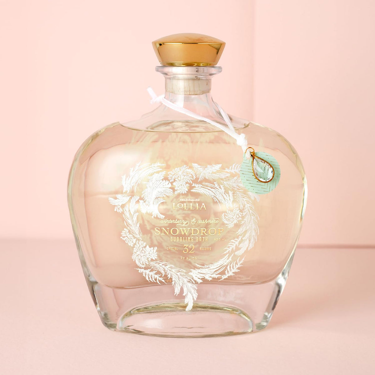 Lollia Snowdrop cork and white velvet ribbon on premium bottle.