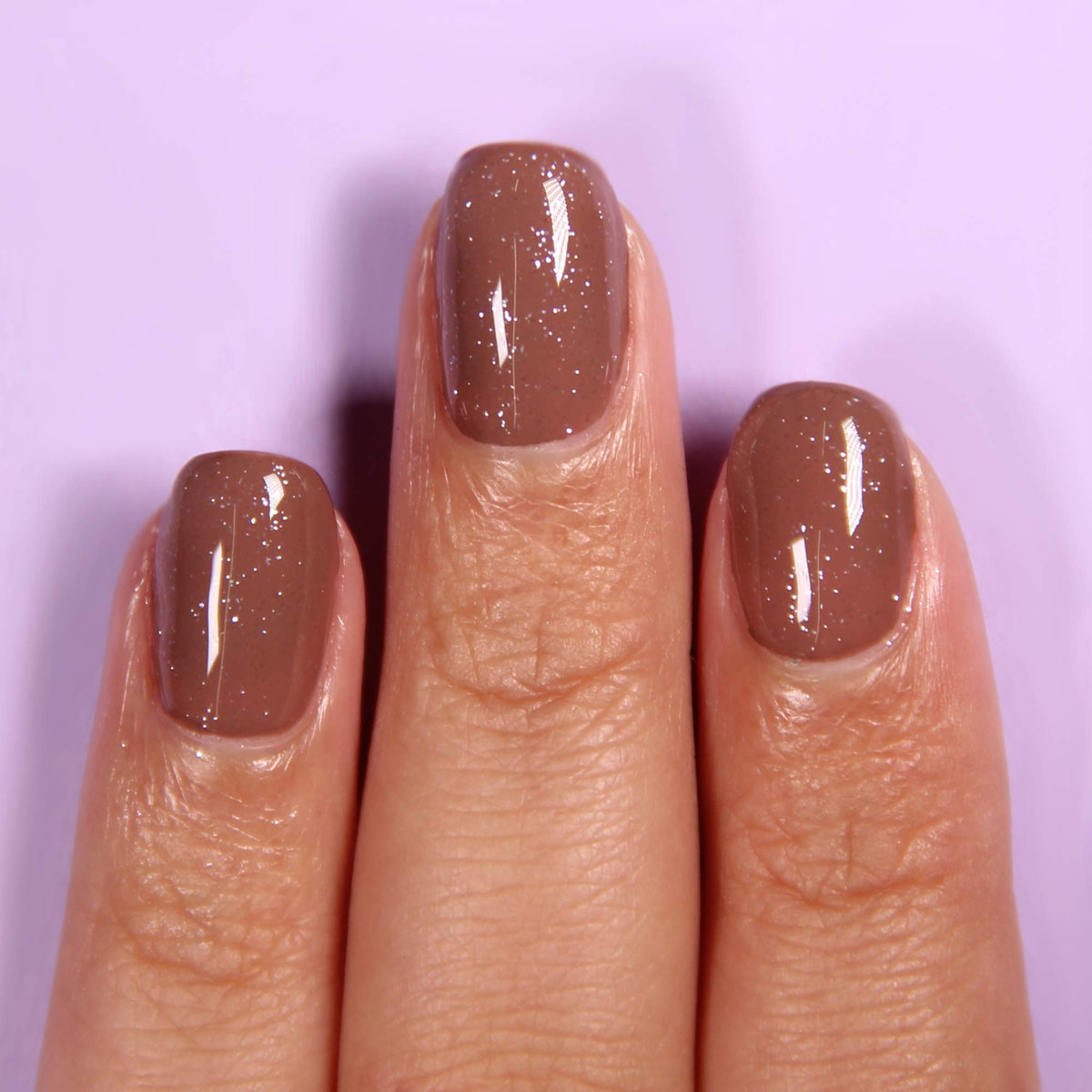 LONDONTOWN Diamond Shine Top Coat on nails adds dimension and high shine.