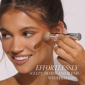 Loving Tan Flawless Face Tan Brush free-standing design in a tidy vanity setting.