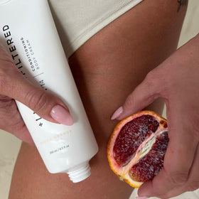 Lux Unfiltered Blood Orange fragrance bottle in bright setting reveals vibrant citrus scent.