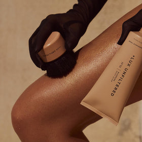 Lux Unfiltered kabuki blending tool applying product for even coverage.