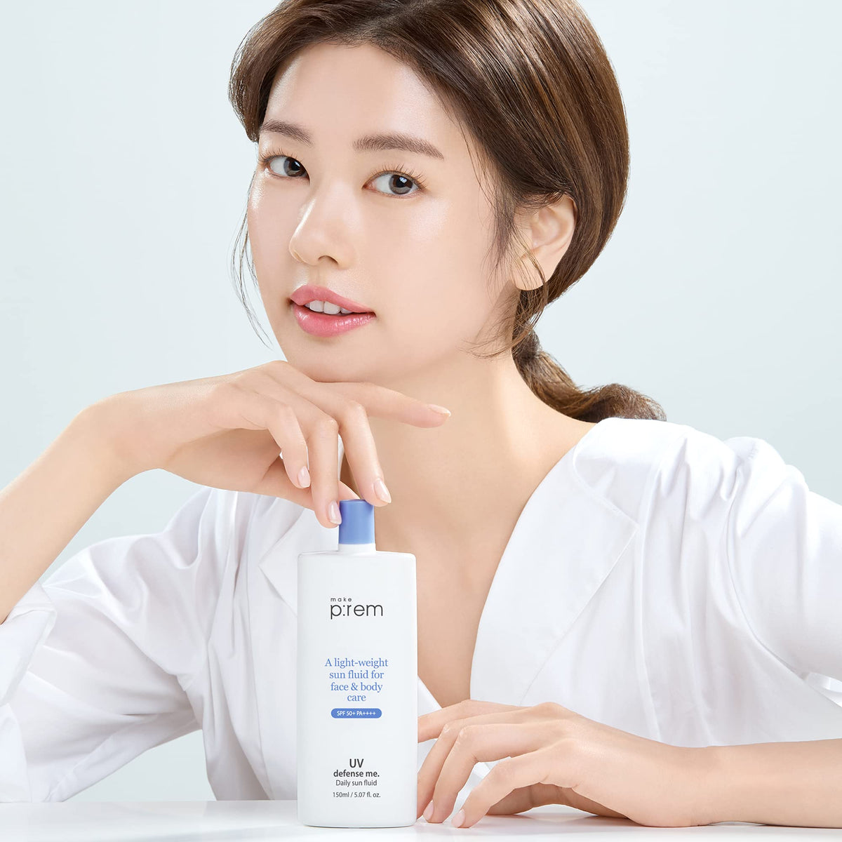 Hand applying MAKEP:REM Defense Me sunscreen on the face during outdoor activity