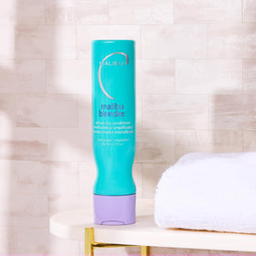 Close-up of Malibu C conditioner texture showing purple formula for detangling