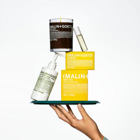 MALIN+GOETZ Rum Body Lotion applied on skin for hydration.