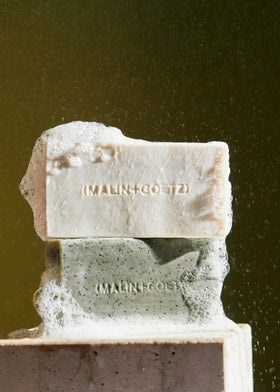MALIN+GOETZ Vitamin B5 Hydrating Bar Rum bar in hand suggests portable cleansing ritual