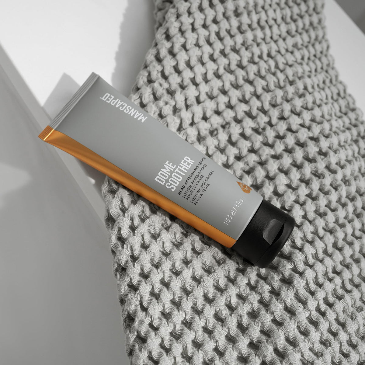 Manscaped Dome Soother packaging beside bottle highlights branding.