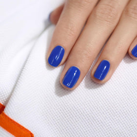 Sunlit bottle of Manucurist Green Ultramarine highlights glossy finish.