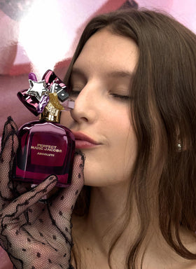 Marc Jacobs Perfect Absolute amber glow bottle against soft lighting for a luxurious vibe.