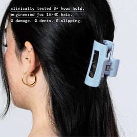MELLO light blue small claw clip worn in hair for comfortable styling.