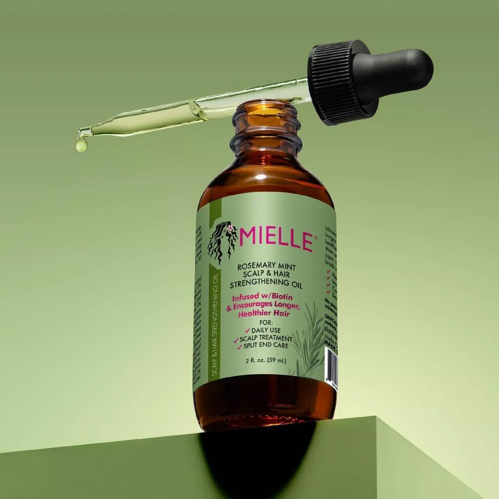 Mielle Organics Rosemary Mint oil bottle closeup highlights natural ingredients.