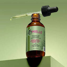 Mielle Organics Rosemary Mint oil bottle closeup highlights natural ingredients.