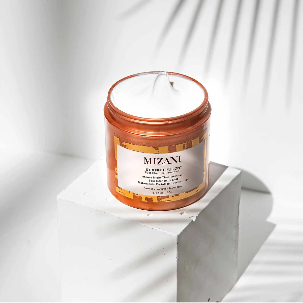 Packaging detail of Mizani Strength Fusion Night-Time Treatment highlighting anti-breakage tech