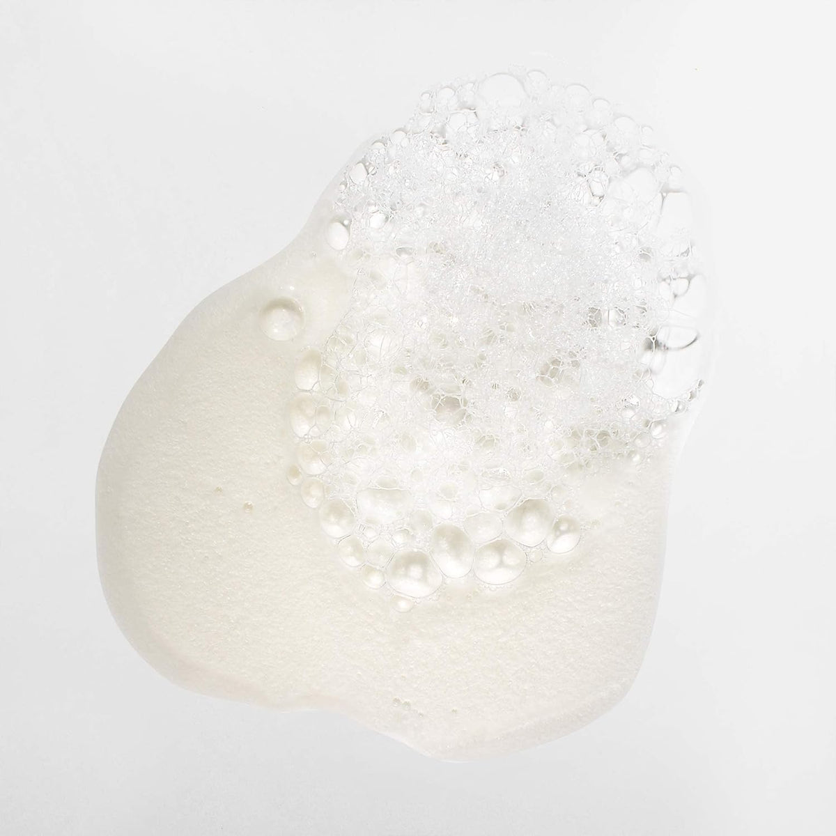 Open Mizani bottle pouring shampoo to show generous lather