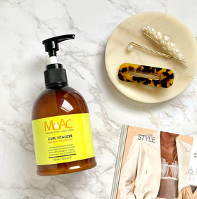 Moac Curl Vitalizer product shot emphasizing non-greasy formula.