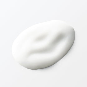 Hands applying MUJI lotion during daily skincare routine.