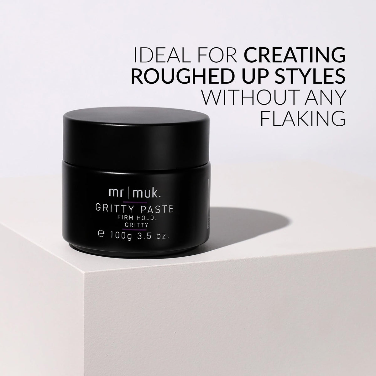 Applying Mr MUK paste in hands for easy, even distribution on dry hair.
