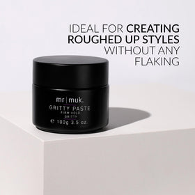 Applying Mr MUK paste in hands for easy, even distribution on dry hair.