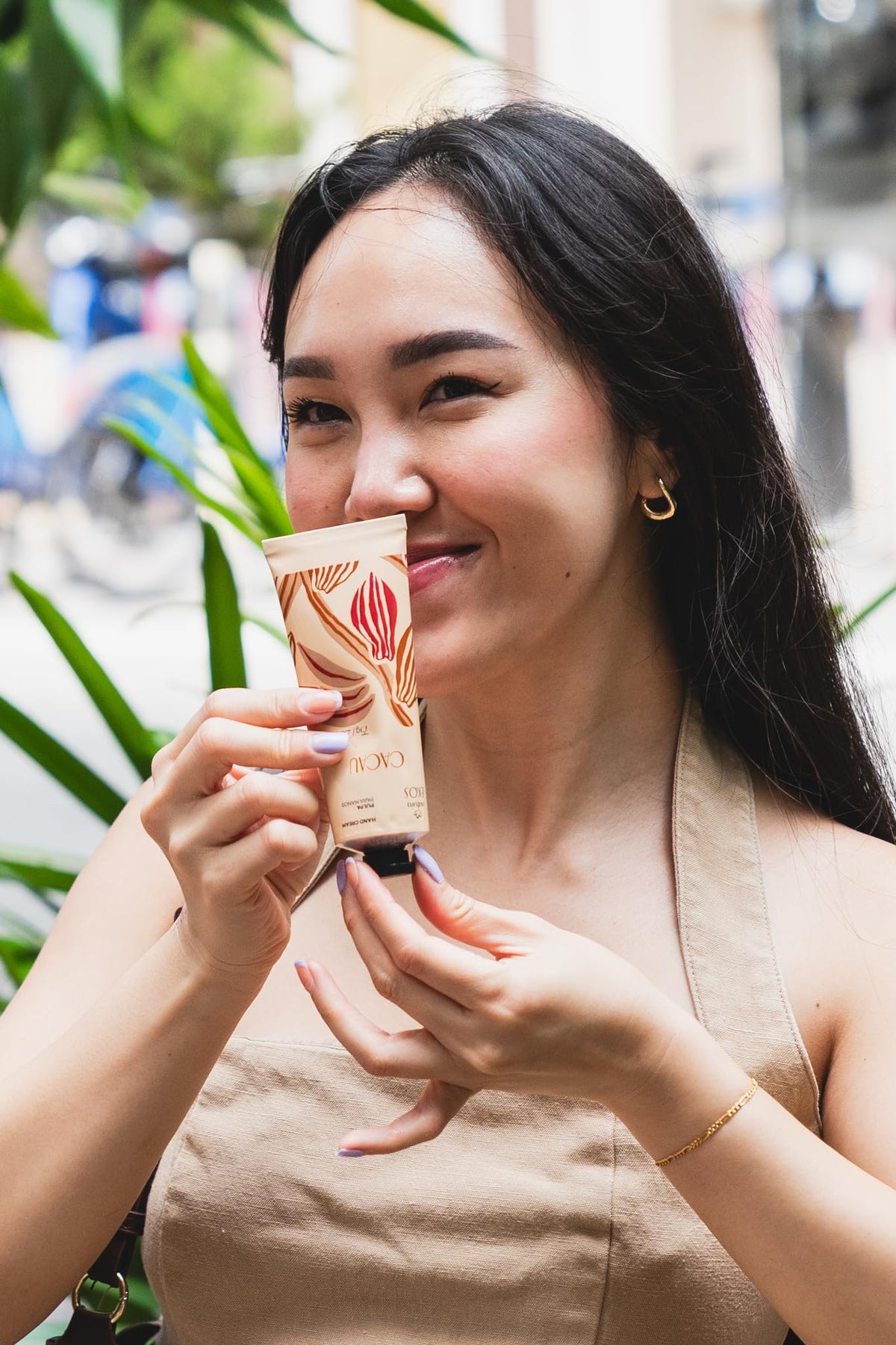 Natura Ekos Cacau hand cream with a delicate cocoa scent on hands.