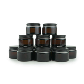 Nature Packaged amber jar with black lid, travel-friendly cosmetic container.