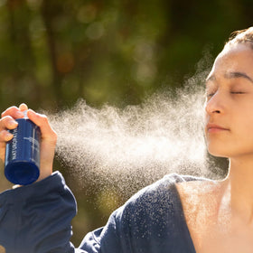 Hand holds Naturopathica mist for daily refresh.
