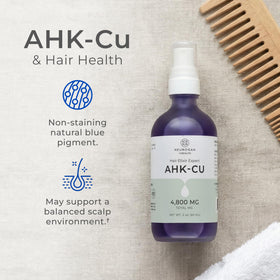 Neurogan AHK-Cu Hair Elixir in hand ready to apply to scalp.