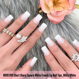 NOVO OVO milky white nail tips applied with adhesive for quick DIY manicure.