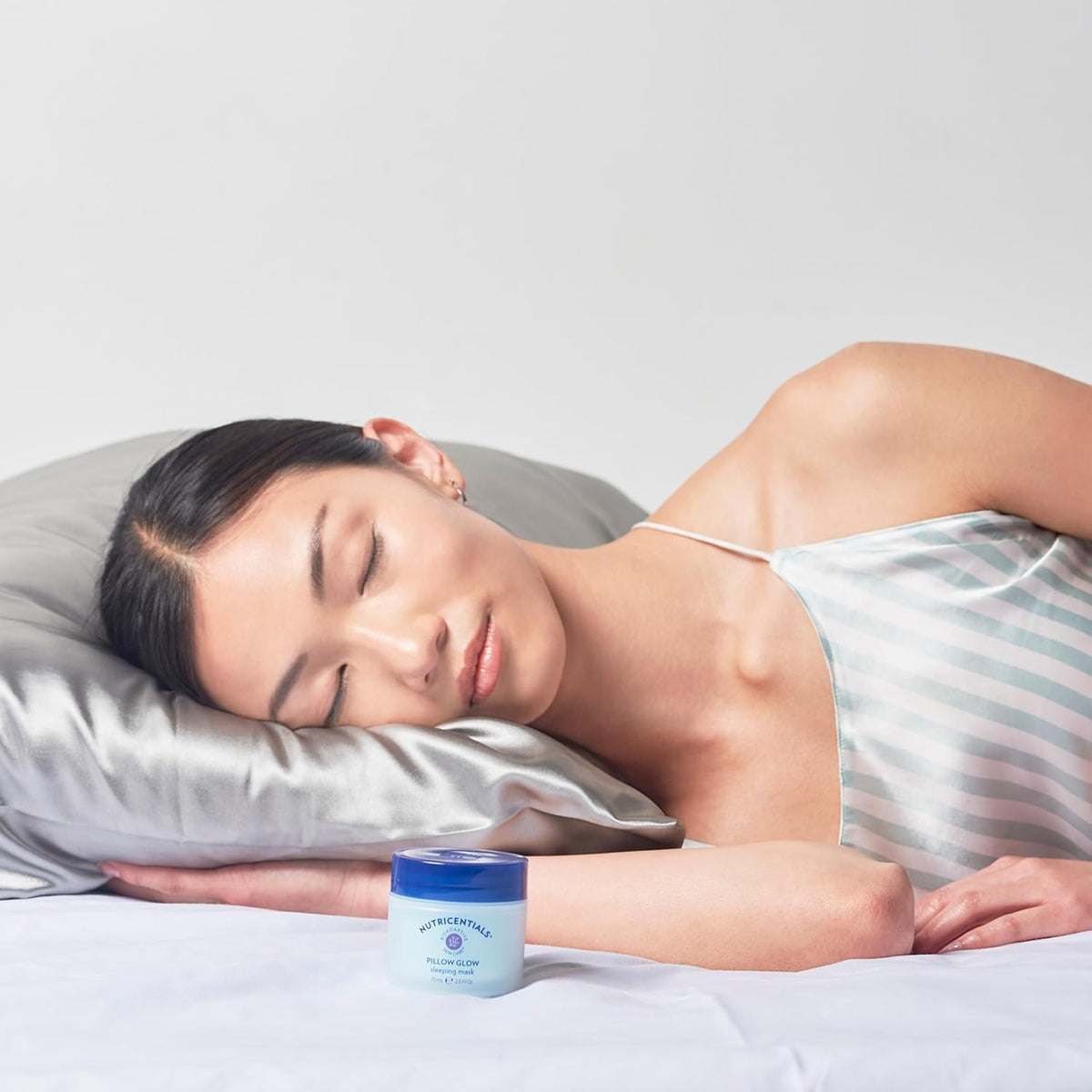 Nu Skin Pillow Glow bottle close-up highlights premium nightly formula.