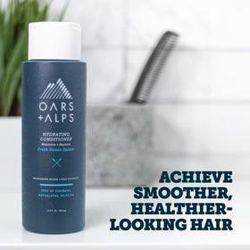 Oars + Alps Hydrating Conditioner label close-up highlights sulfate-free formula for smoother strands.