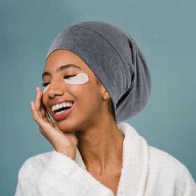 OLESILK silk bonnet resting beside pillow highlights nightly routine.