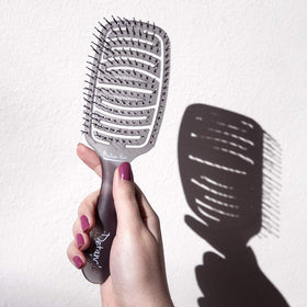 Olivia Garden iDetangle brush in hand detangling wet hair.