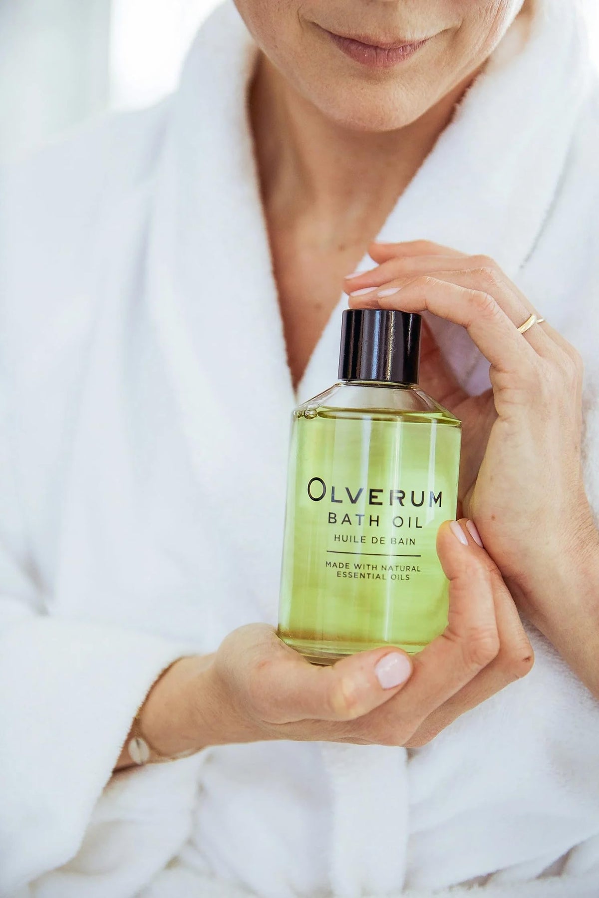 OLVERUM bath oil surrounded by natural plant extracts from the formula.