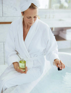 Relaxing bathroom scene with OLVERUM bath oil under soft lighting.