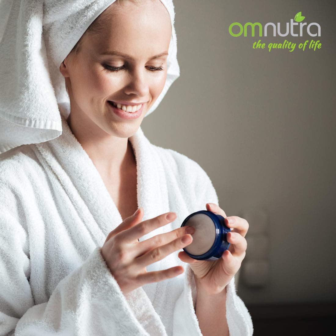 Hands applying OmNutra OncoEase moisturizer for dry skin care.