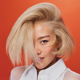 Close-up of ORIBE bottle emphasizing cuticle smoothing and elasticity
