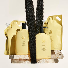 Oribe Hair Alchemy Resilience Shampoo bathroom shelf scene suggests protective care.