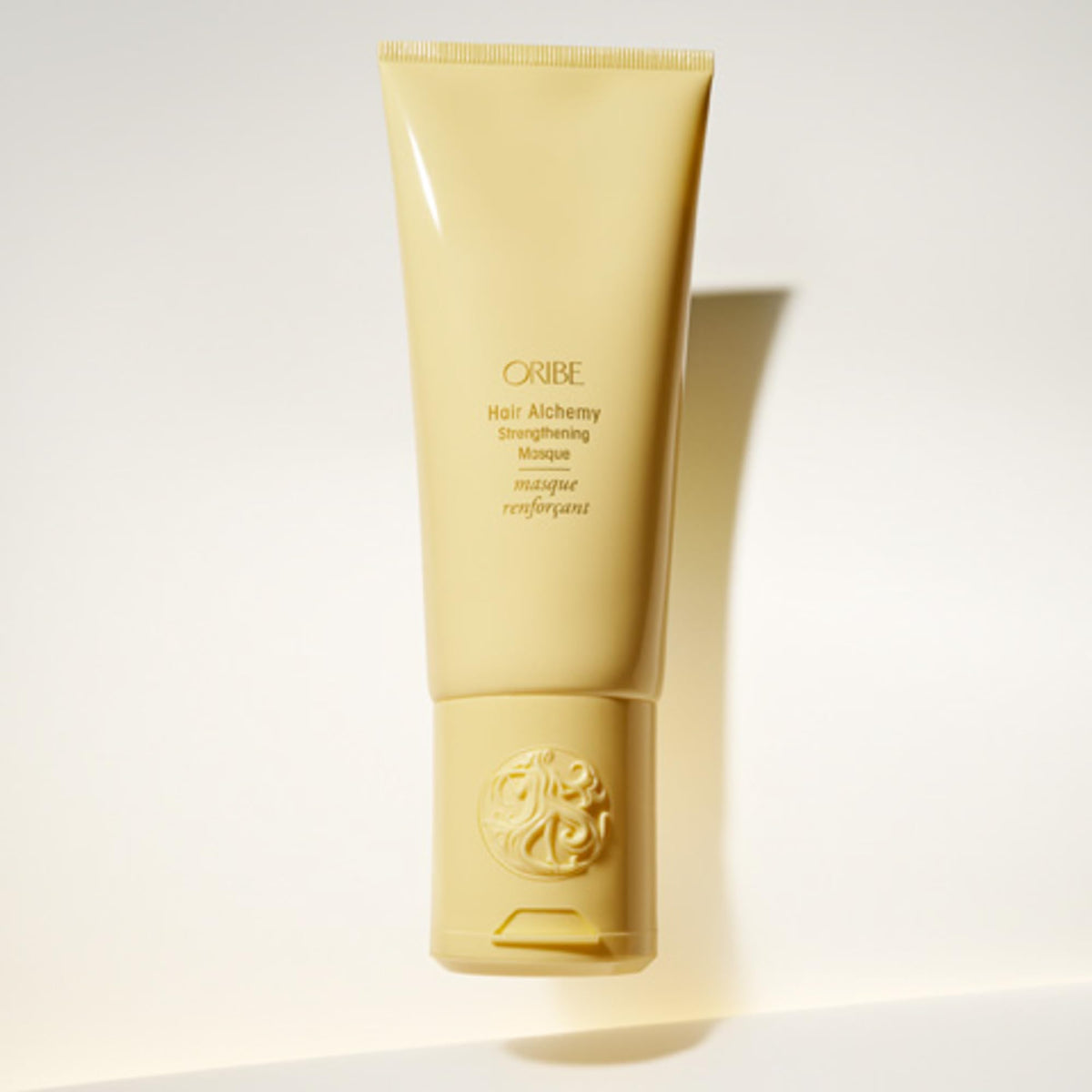 Oribe Hair Alchemy Strengthening Masque on a vanity evokes luxury hair care rituals.