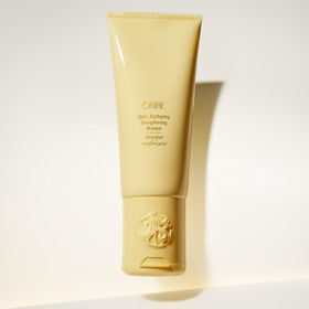 Oribe Hair Alchemy Strengthening Masque on a vanity evokes luxury hair care rituals.