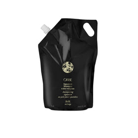 Oribe Signature Shampoo bottle on shelf for premium cleansing across hair types.
