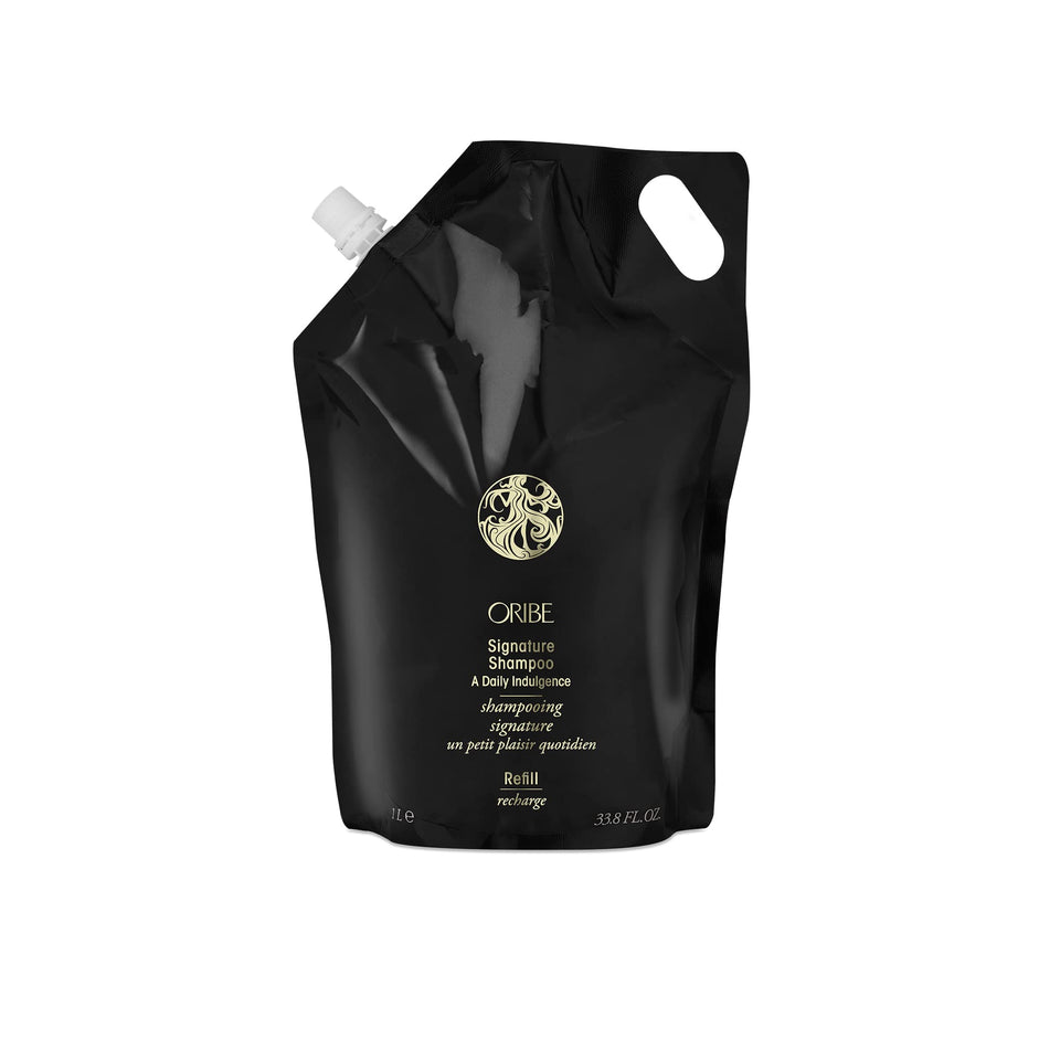 Oribe Signature Shampoo bottle on shelf for premium cleansing across hair types.