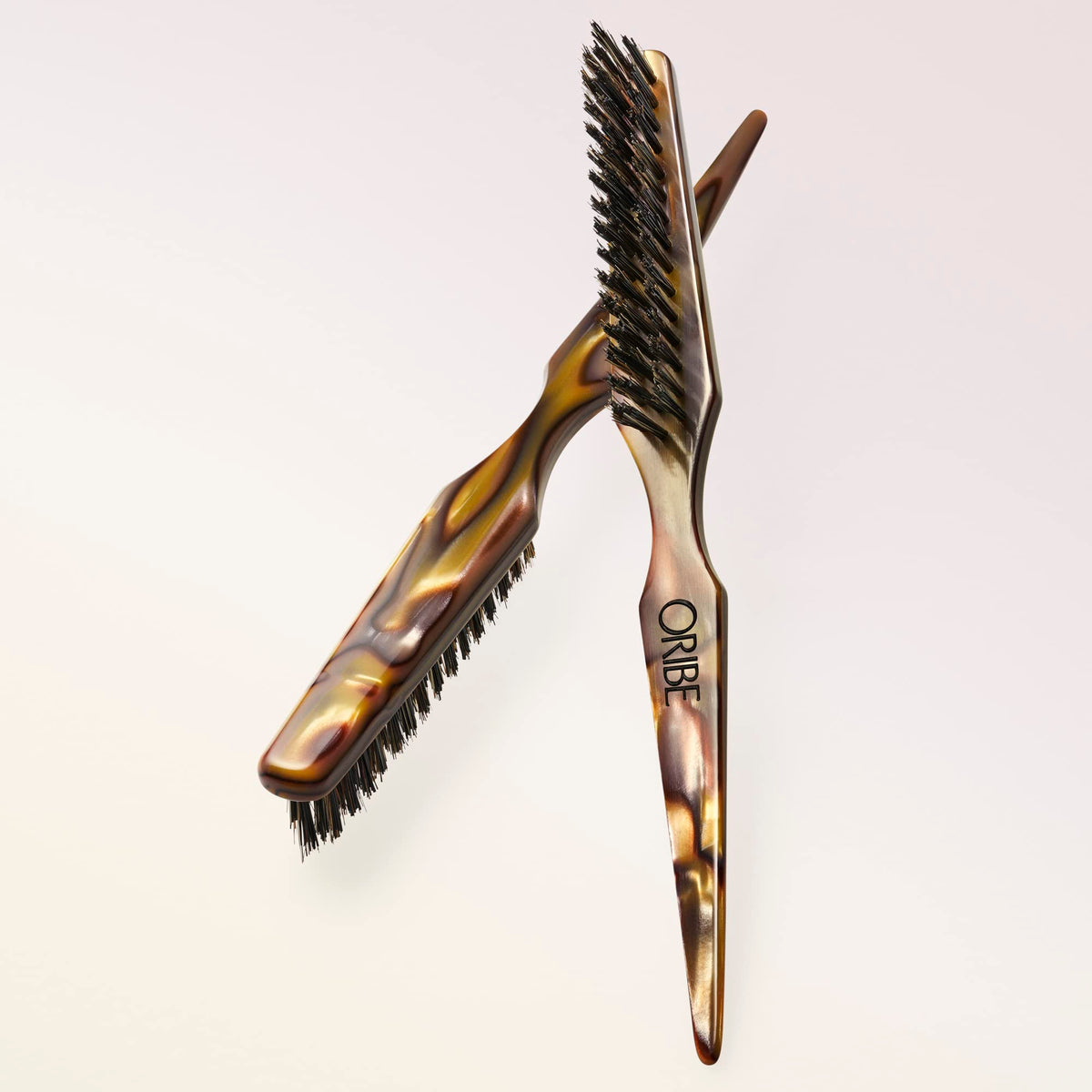 Oribe Teasing Brush's boar bristles and nylon pins add volume and precise lift.