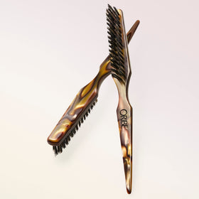 Oribe Teasing Brush's boar bristles and nylon pins add volume and precise lift.