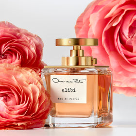 Oscar de la Renta Alibi fragrance bottle with warm lighting, luxury vibe.