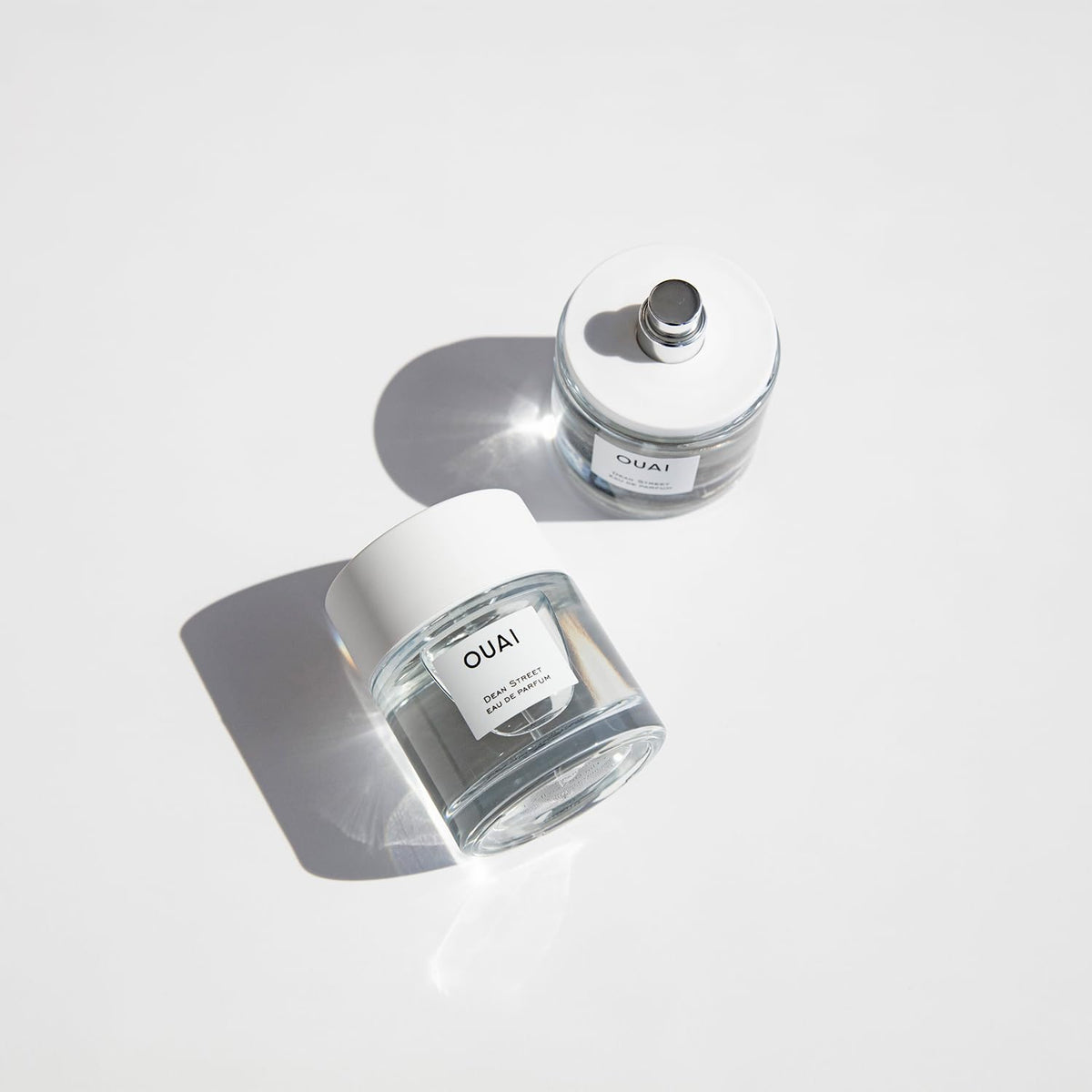 OUAI Dean Street EDP glass bottle beside soft lighting ambience