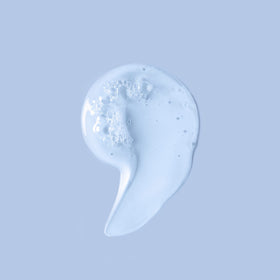 Ouidad Unbreakable Bonds Shampoo on bathroom shelf with droplets suggesting refreshing hydration.