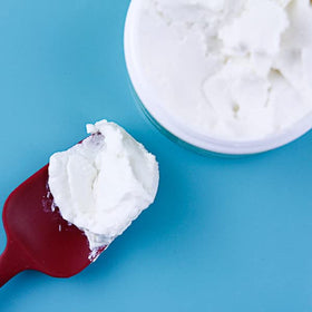 Hands applying Oyin Handmade Whipped Pudding demonstrates versatile hair and skin care