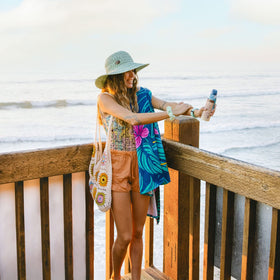 Beach scene with Panama Jack sunscreen bottle ready for sun day.