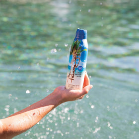 Angled Panama Jack SPF 100 bottle sits on a towel for travel-ready protection.