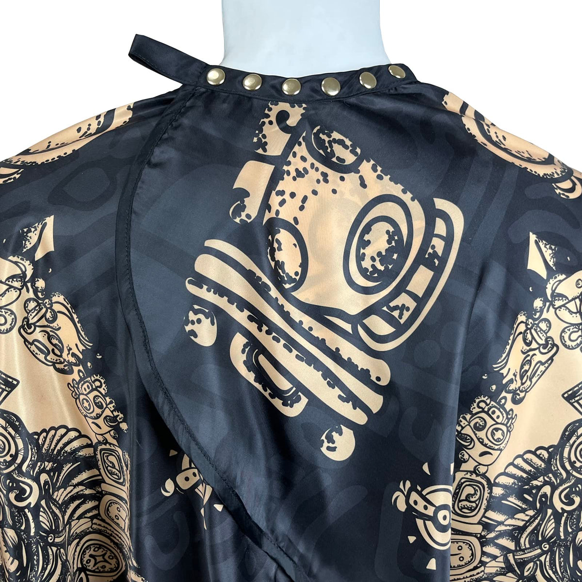 Pelocapa barber cape with copper snap closures providing secure neck fit