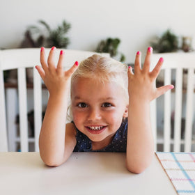 Child applying Piggy Paint Swirls & Twirls with a smile.